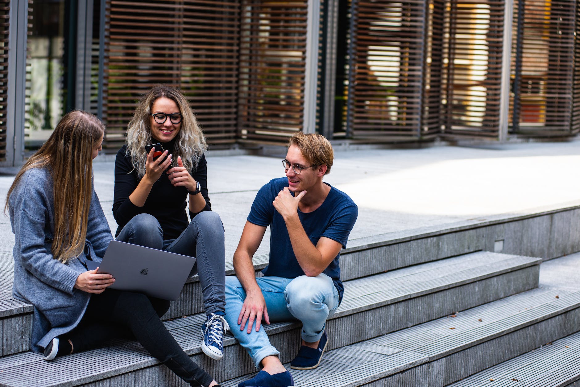 pexels-photo-1438072 three persons sitting on the stairs talking with each other