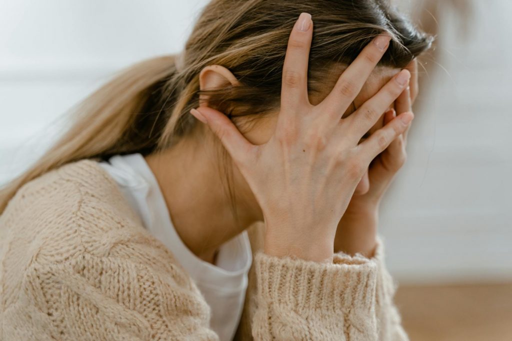 woman covering her face with her hands
