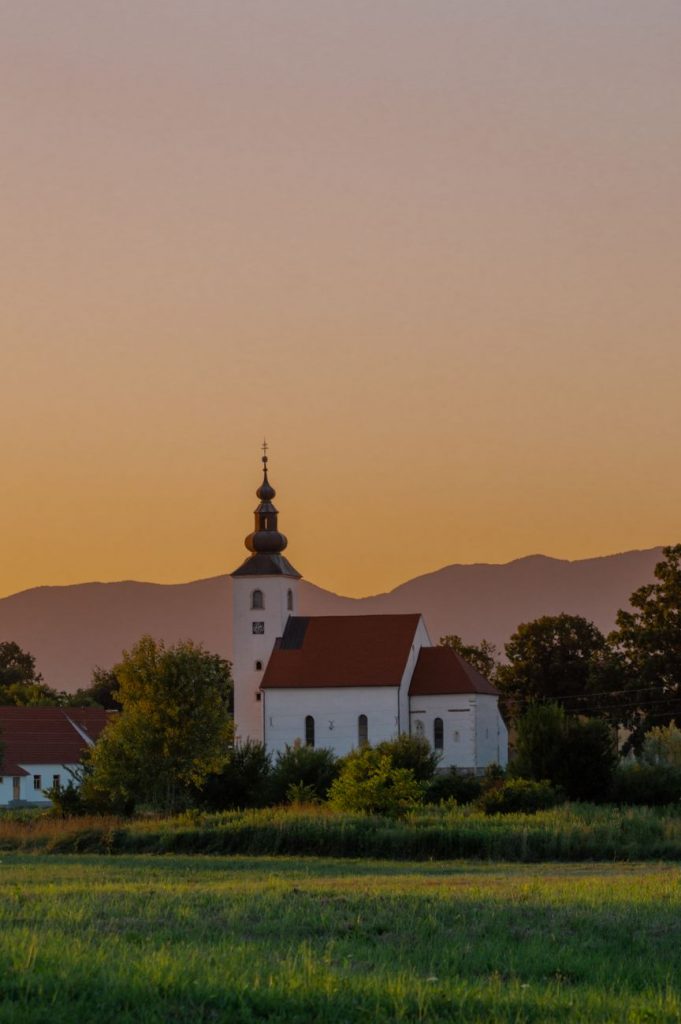 church near grassland during dusk