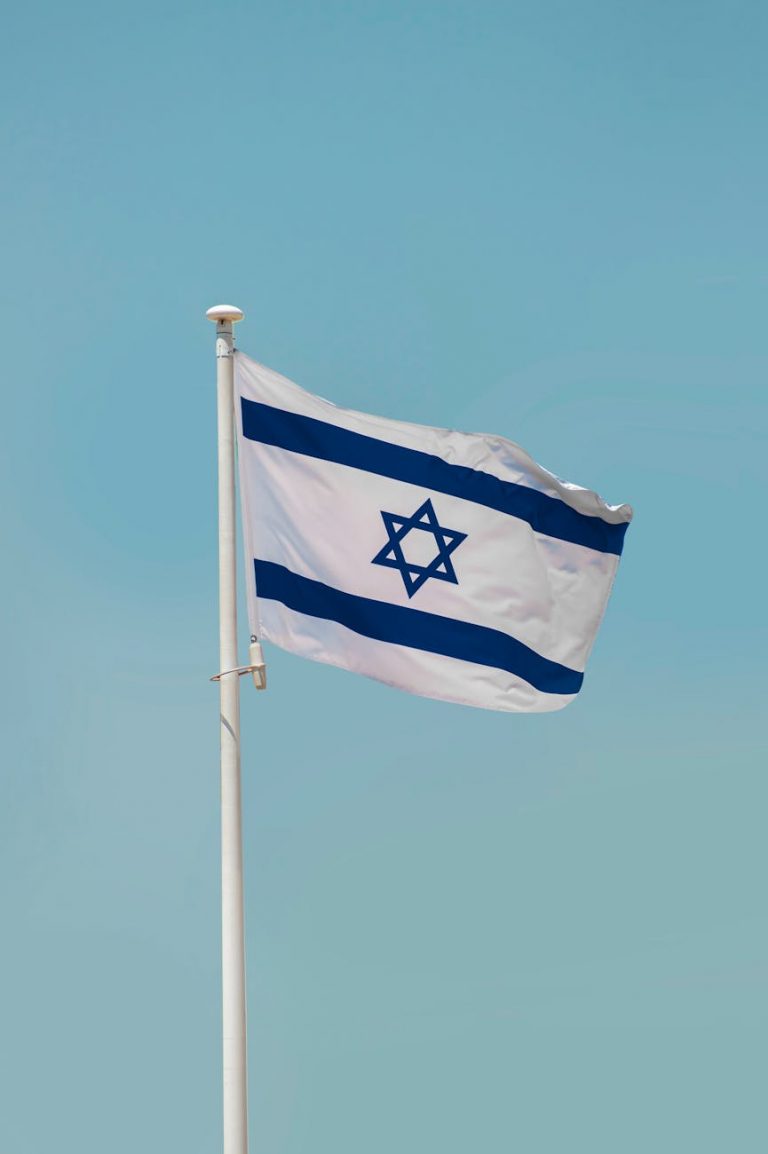 flag of israel on white pole under blue sky