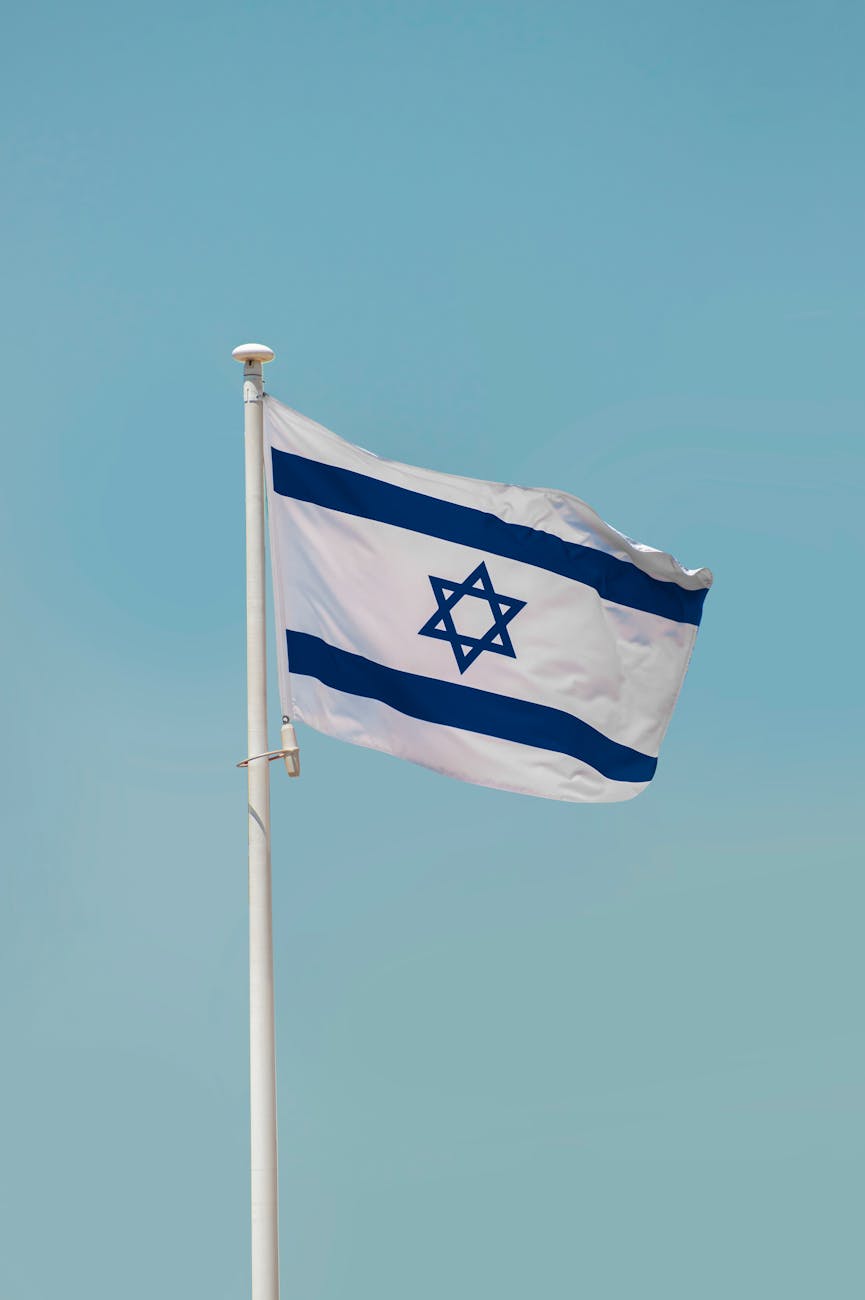 flag of israel on white pole under blue sky