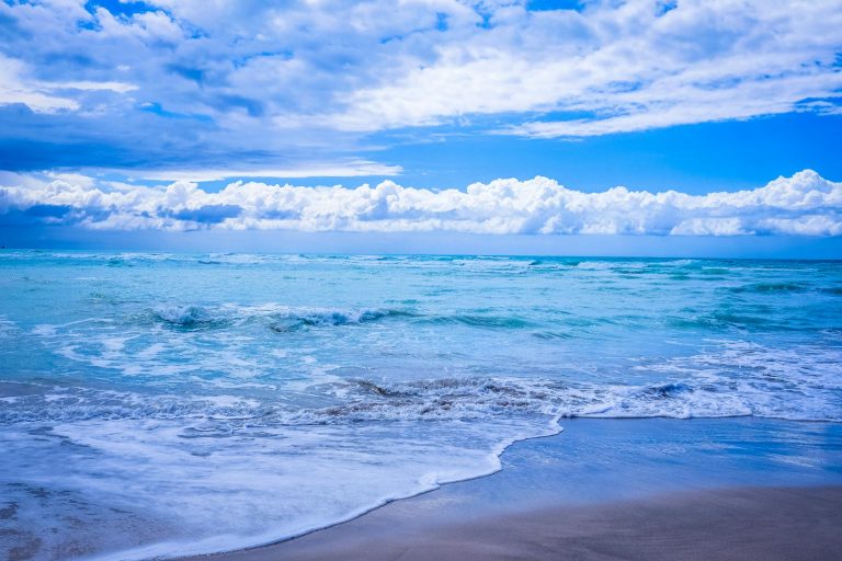 body of water under blue and white skies