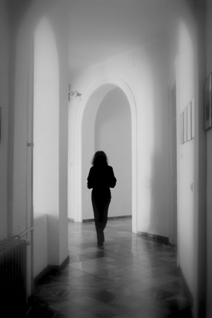 back view of woman walking in corridor