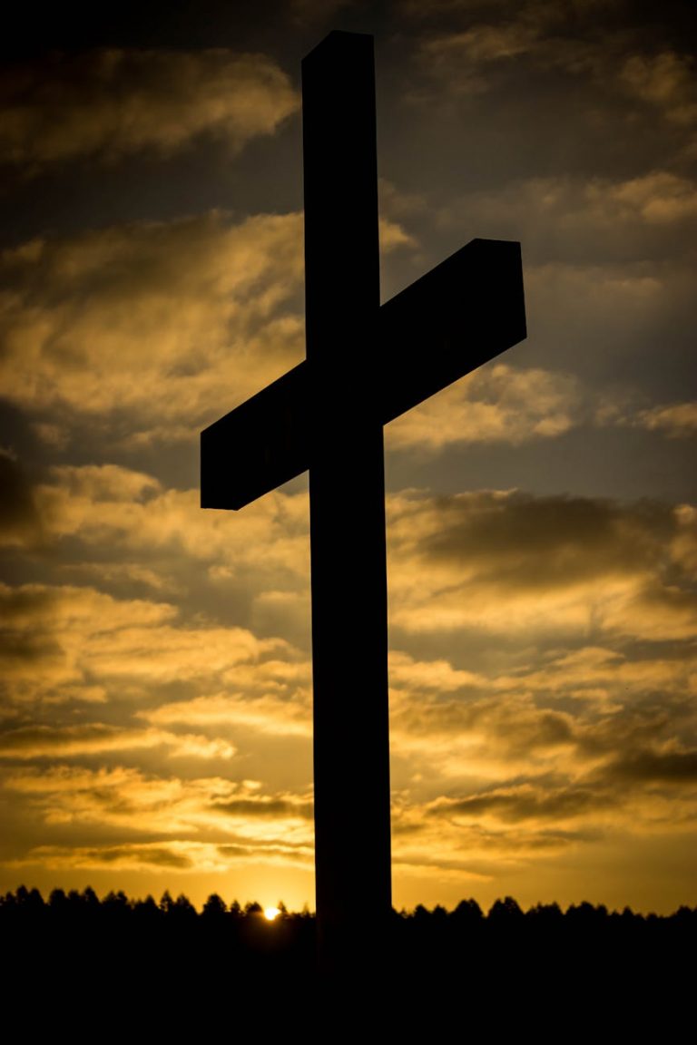 a low angle shot of a silhouette of a cross
