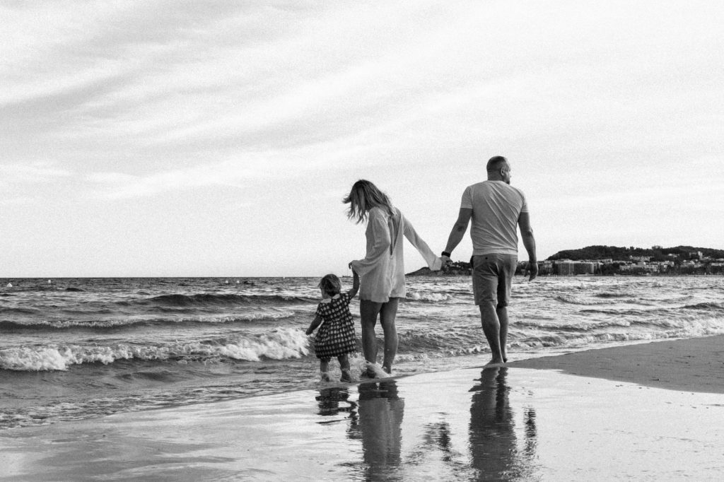 family stroll on the beach in black and white