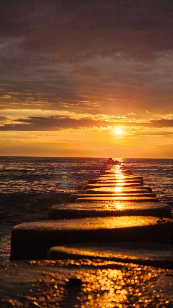 golden sunset over ocean with pier