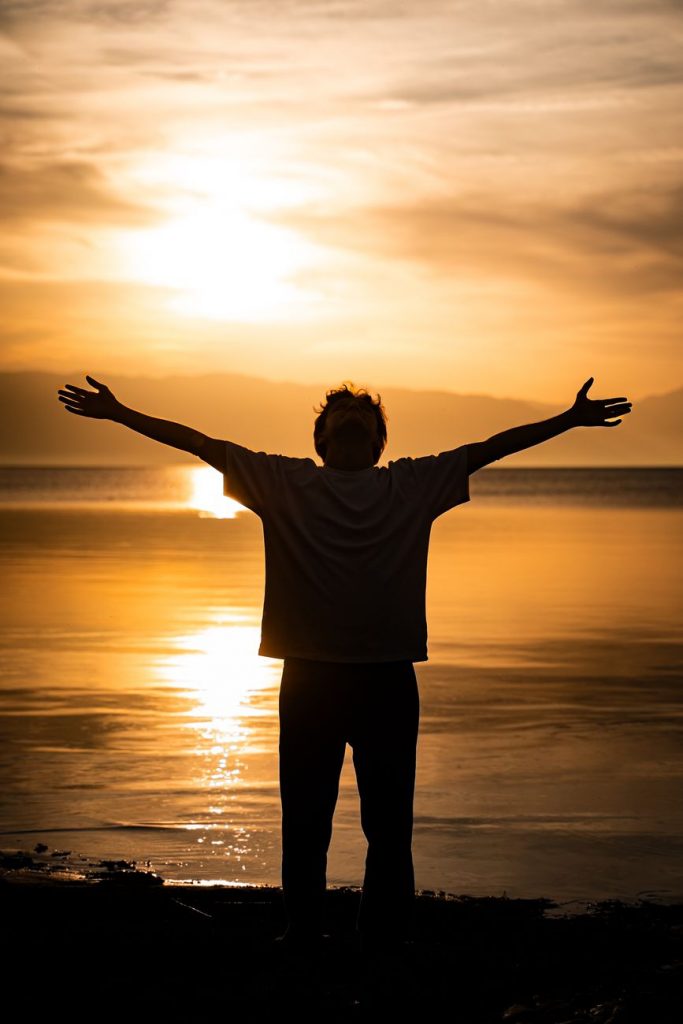 silhouette of person at sunset by the lake
